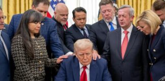 El presidente Donald Trump sentado en el Despacho Oval, rodeado de líderes evangélicos que le imponen las manos en señal de oración, incluyendo a su consejera espiritual Paula White-Cain.