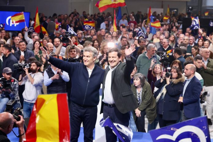 Alfonso Fernández Mañueco y Alberto Núñez Feijóo celebran los resultados electorales en Castilla y León rodeados de simpatizantes con banderas de España y del PP.