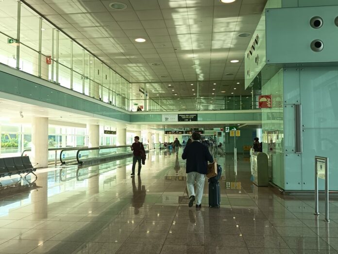 Pasajero con maleta caminando por la Terminal 1 del Aeropuerto de Barcelona-El Prat.