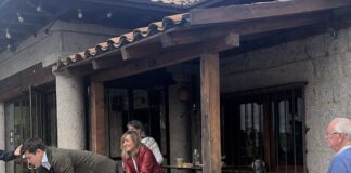 Vito Quiles sobre una mesa y detrás de él los acompañantes de Begoña Gómez.