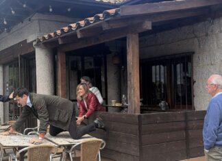 Vito Quiles sobre una mesa y detrás de él los acompañantes de Begoña Gómez.