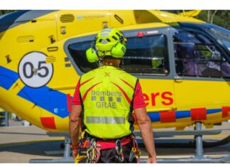 Bombero del GRAE de los Bombers de la Generalitat junto a un helicóptero de rescate