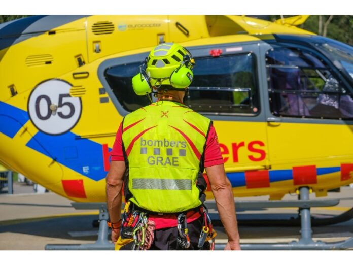 Bombero del GRAE de los Bombers de la Generalitat junto a un helicóptero de rescate