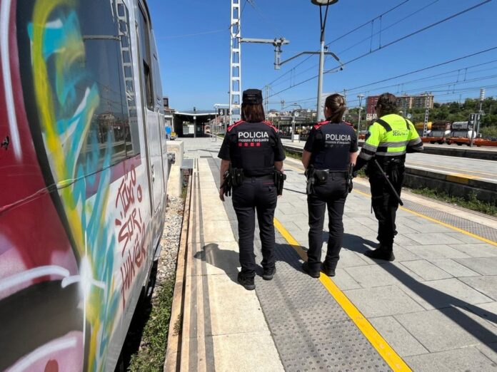 Agentes de Mossos d’Esquadra junto a un tren con grafitis en una estación de Cataluña