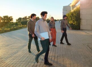 Imagen conceptual de jóvenes profesionales con portátiles y maletas en una terminal de aeropuerto, con el anuncio de Banco Santander de 400+ oportunidades laborales globales.