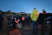 Grupo de personas realizando una observación astronómica nocturna bajo un cielo estrellado en las Muntanyes de Prades.