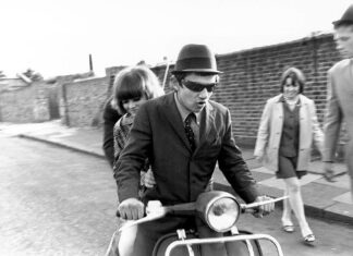 Jóvenes en scooter en una calle en blanco y negro durante los años sesenta.