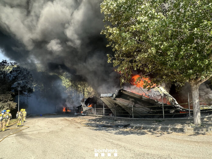 Incendio en una industria de Òrrius con una gran columna de humo y los Bombers trabajando en la zona