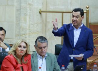 El presidente de Andalucía, Juanma Moreno, en una intervención en el Parlamento andaluz junto a diputados del PP.