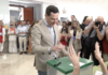 Juanma Moreno Bonilla votando en las elecciones andaluzas de 2026 rodeado de periodistas y fotógrafos.
