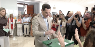 Juanma Moreno Bonilla votando en las elecciones andaluzas de 2026 rodeado de periodistas y fotógrafos.