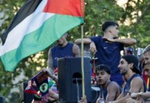 Lamine Yamal junto a una bandera palestina durante la rúa del FC Barcelona por las calles de Barcelona.
