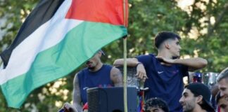 Lamine Yamal junto a una bandera palestina durante la rúa del FC Barcelona por las calles de Barcelona.
