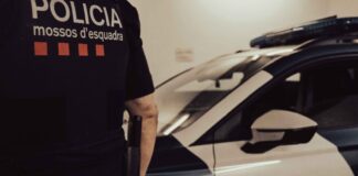 Agente de los Mossos d’Esquadra junto a un coche patrulla en una imagen de archivo.