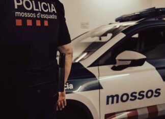 Agente de los Mossos d’Esquadra junto a un coche patrulla en una imagen de archivo.