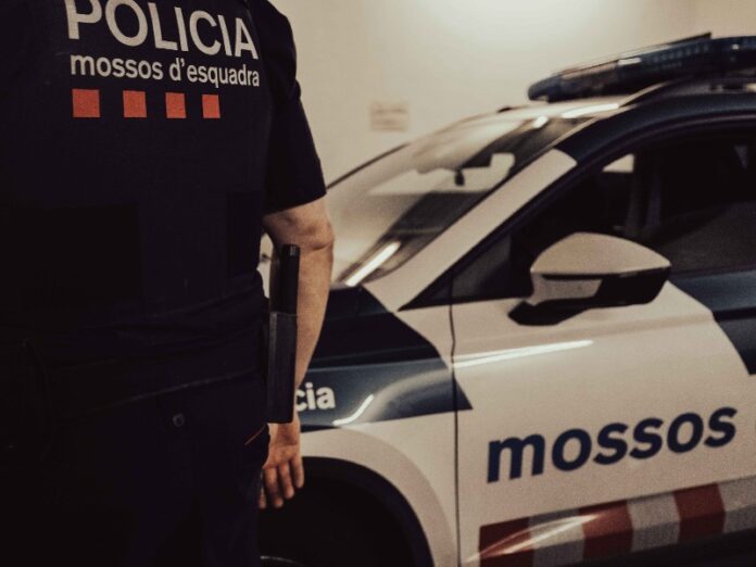 Agente de los Mossos d’Esquadra junto a un coche patrulla en una imagen de archivo.