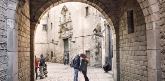 Personas paseando en una calle del centro histórico de Barcelona con edificios patrimoniales