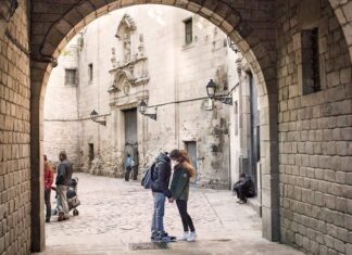Personas paseando en una calle del centro histórico de Barcelona con edificios patrimoniales