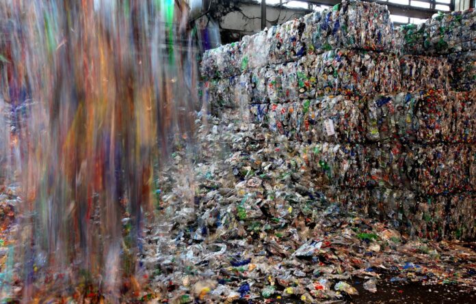 Grandes bloques de residuos plásticos compactados en una planta industrial de reciclaje.