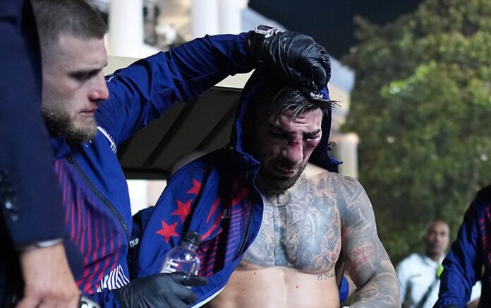 Ilia Topuria, con el rostro visiblemente dañado tras su derrota, recibe asistencia en los instantes posteriores al combate.