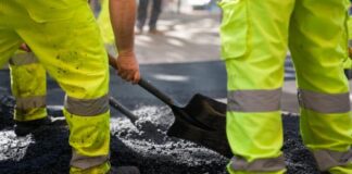 Trabajadores realizan labores de pavimentación en una calle de Barcelona durante las obras previstas para el verano de 2026.