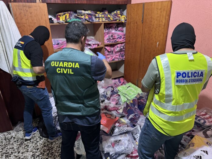 Agentes de los Mossos d'Esquadra, la Guardia Civil y la Policía Nacional inspeccionan productos falsificados durante una operación contra el top manta.