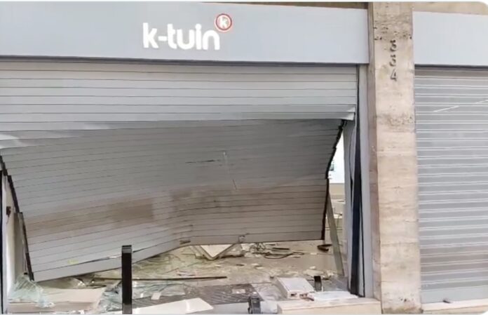 Persiana destrozada de la tienda K-tuin tras el alunizaje ocurrido en la calle Muntaner de Barcelona.