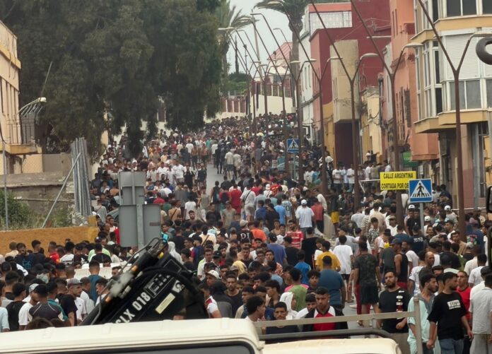 Calle de Ceuta abarrotada de personas tras la llegada masiva de inmigrantes desde Marruecos.
