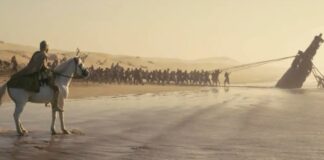 Escena de la película 'La Odisea' de Christopher Nolan con un barco varado en la playa.