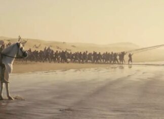 Escena de la película 'La Odisea' de Christopher Nolan con un barco varado en la playa.