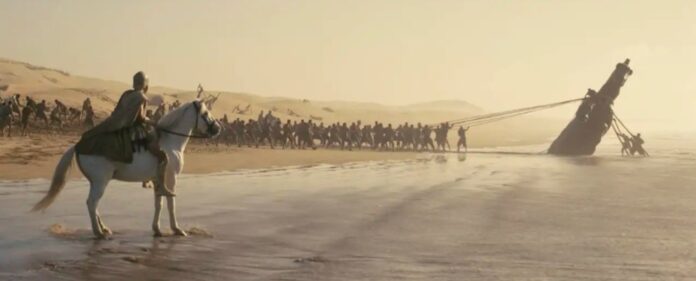 Escena de la película 'La Odisea' de Christopher Nolan con un barco varado en la playa.