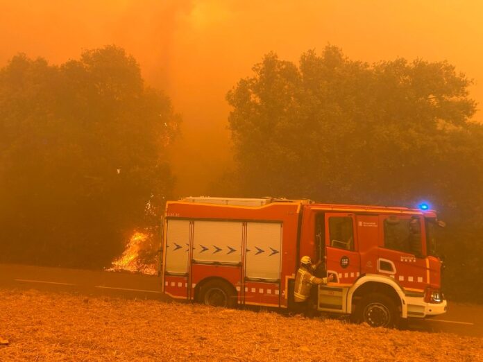 Un camión de Bombers de la Generalitat trabaja durante el incendio forestal de La Bisbal d'Empordà mientras se mantienen confinados siete municipios.