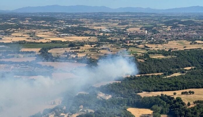 Vista aérea de la columna de humo provocada por el incendio forestal declarado en La Bisbal d'Empordà.