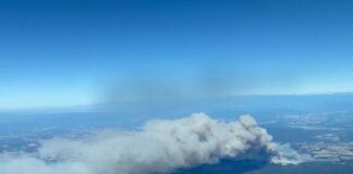 Vista aérea de la gran columna de humo provocada por el incendio forestal de Les Gavarres, en el Baix Empordà, junto a varias zonas urbanizadas.
