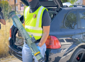 Agente de la Policía Nacional sostiene el lanzacohetes intervenido durante la operación contra una red de tráfico de armas en Cataluña.