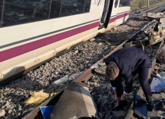 Un hombre examina los restos esparcidos sobre las vías junto a uno de los trenes implicados en el accidente ferroviario ocurrido este miércoles en Toledo.