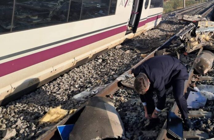 Un hombre examina los restos esparcidos sobre las vías junto a uno de los trenes implicados en el accidente ferroviario ocurrido este miércoles en Toledo.