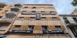 Fachada del edificio de la calle Llenguadoc 74, en Barcelona, con pancartas contra la especulación inmobiliaria y en defensa de sus residentes.