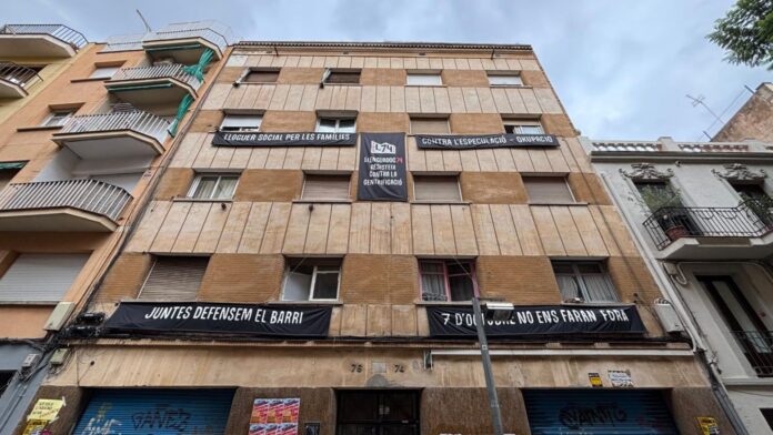 Fachada del edificio de la calle Llenguadoc 74, en Barcelona, con pancartas contra la especulación inmobiliaria y en defensa de sus residentes.